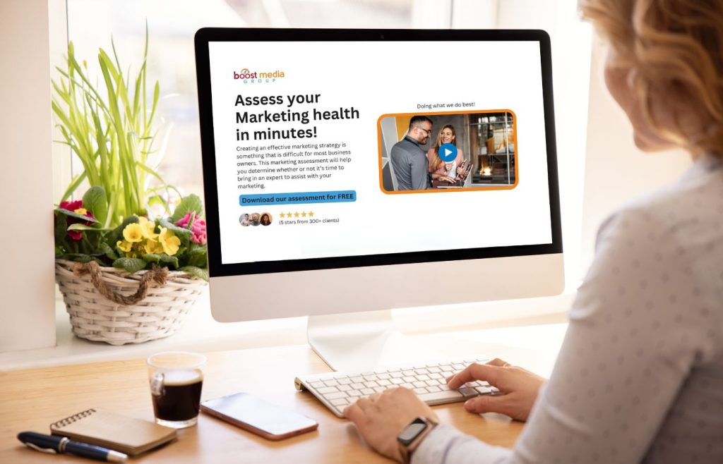 Person sitting at a desk, looking at a computer screen displaying Boost Media Group’s marketing health assessment tool.